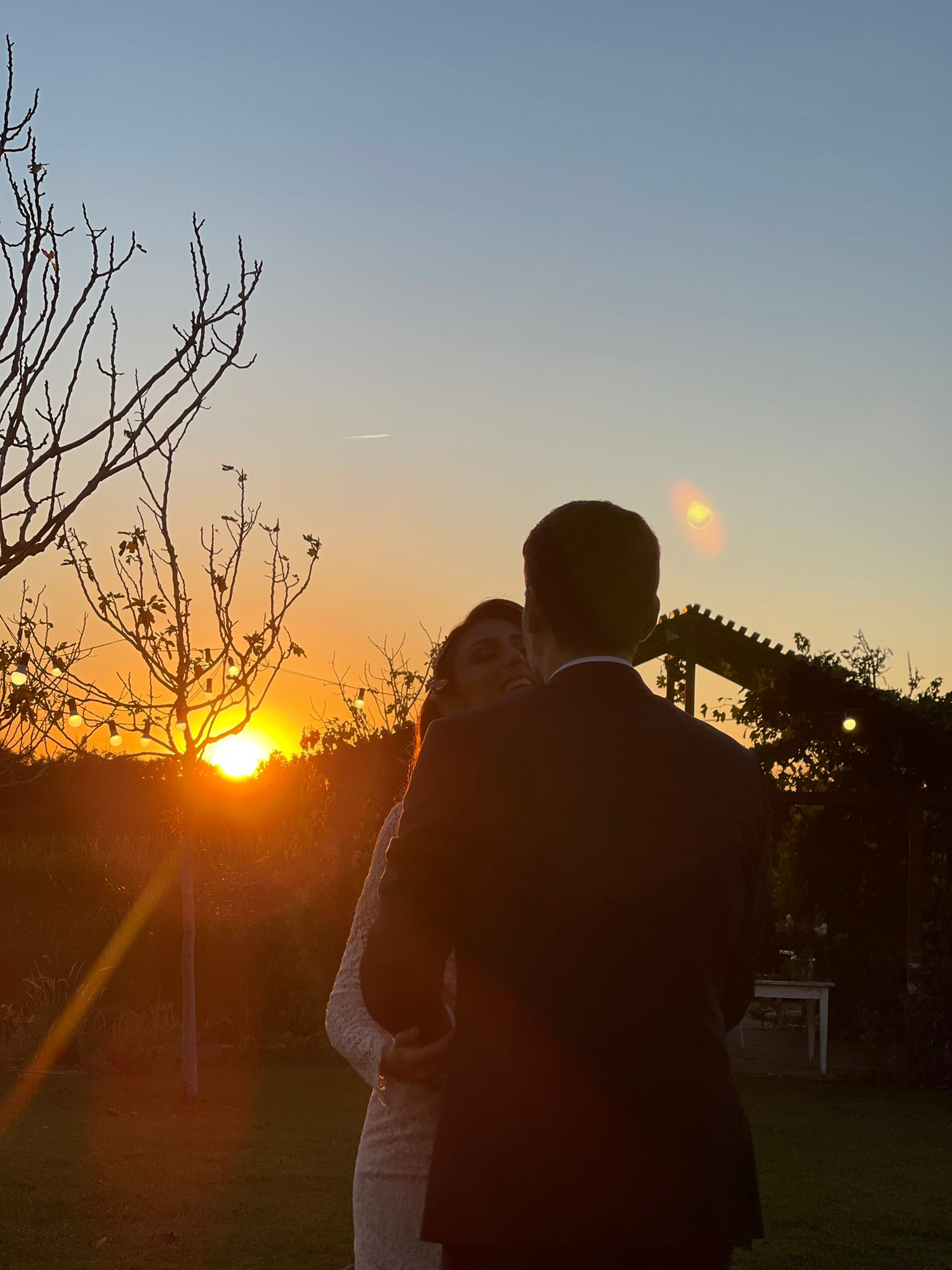 Pareja de recién casados bailando al atardecer